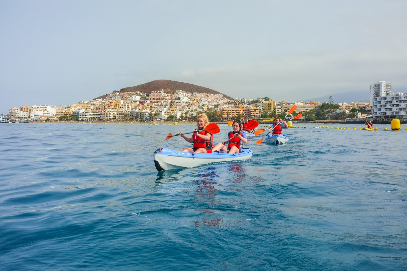 Grupo en kayak con la costa de Los Cristianos de fondo